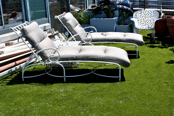 Lounge chairs on top of artificial grass on the rooftop of a Fresno, CA commercial building