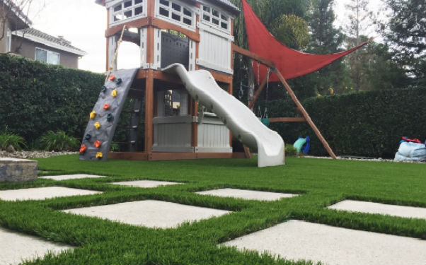Backyard with an artificial grass lawn and playground equipment